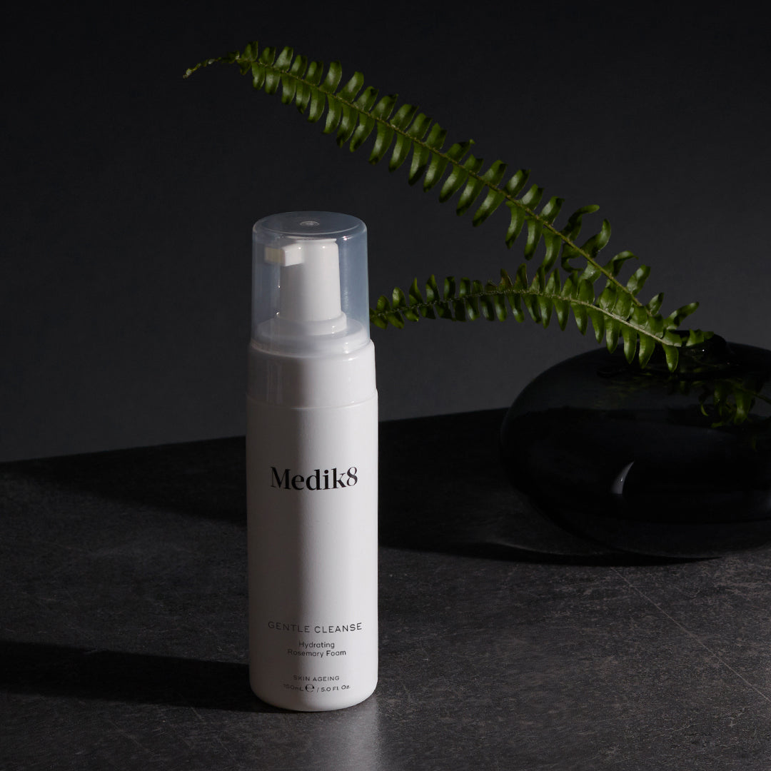 Medik8 Gentle Cleanse flacone su sfondo scuro con felce