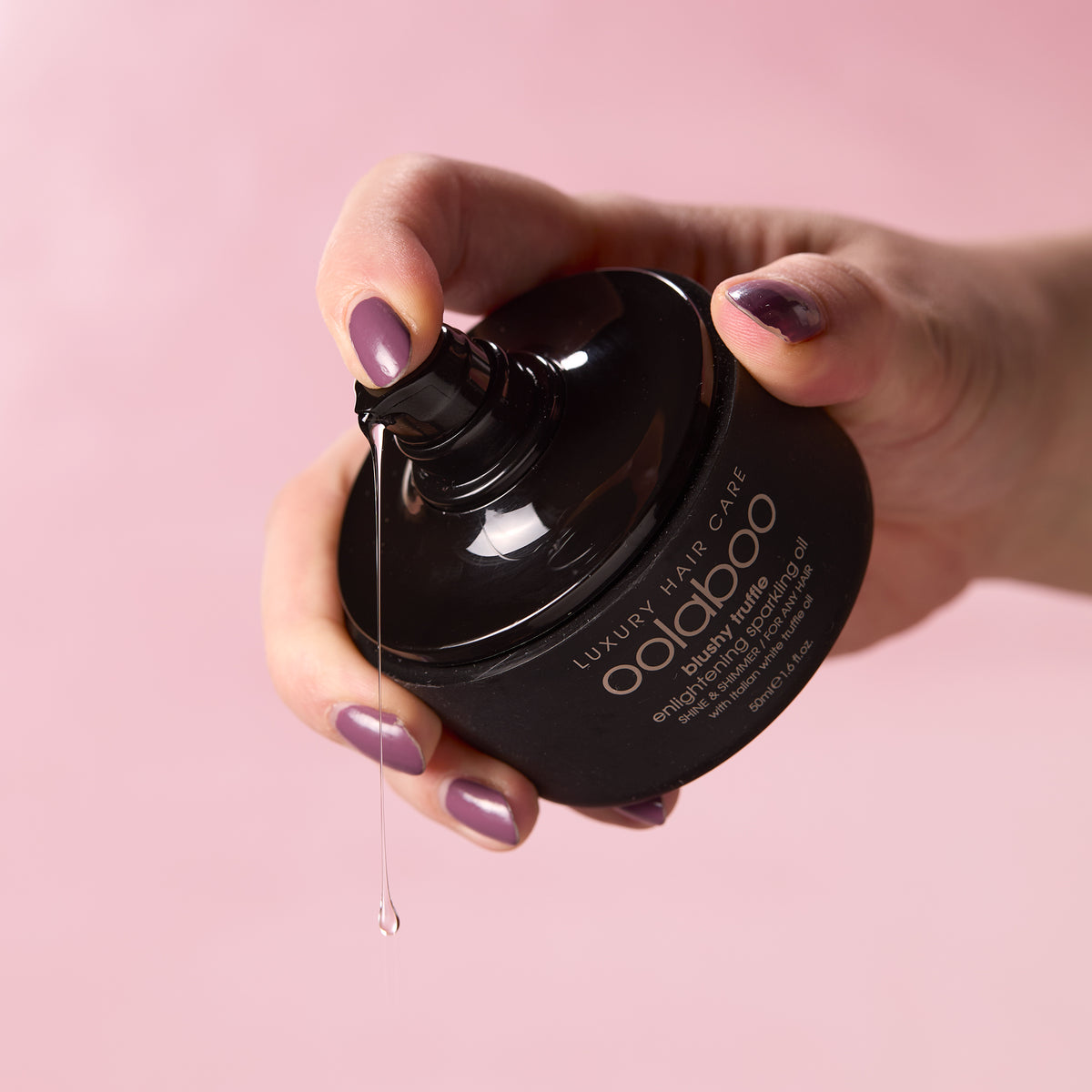 Oolaboo Blushy Truffle Sparkling Oil dosatore con goccia d'olio sulla mano