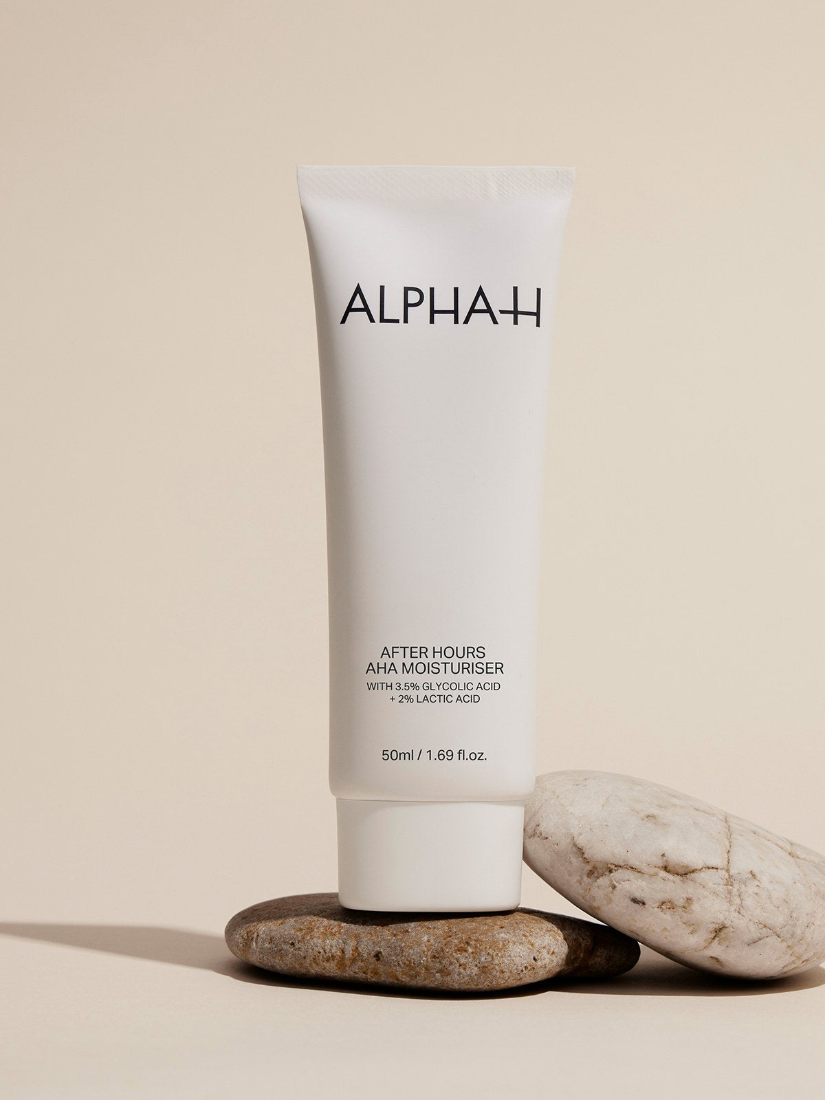 Alpha-H After Hours AHA Moisturiser su una pila di pietre