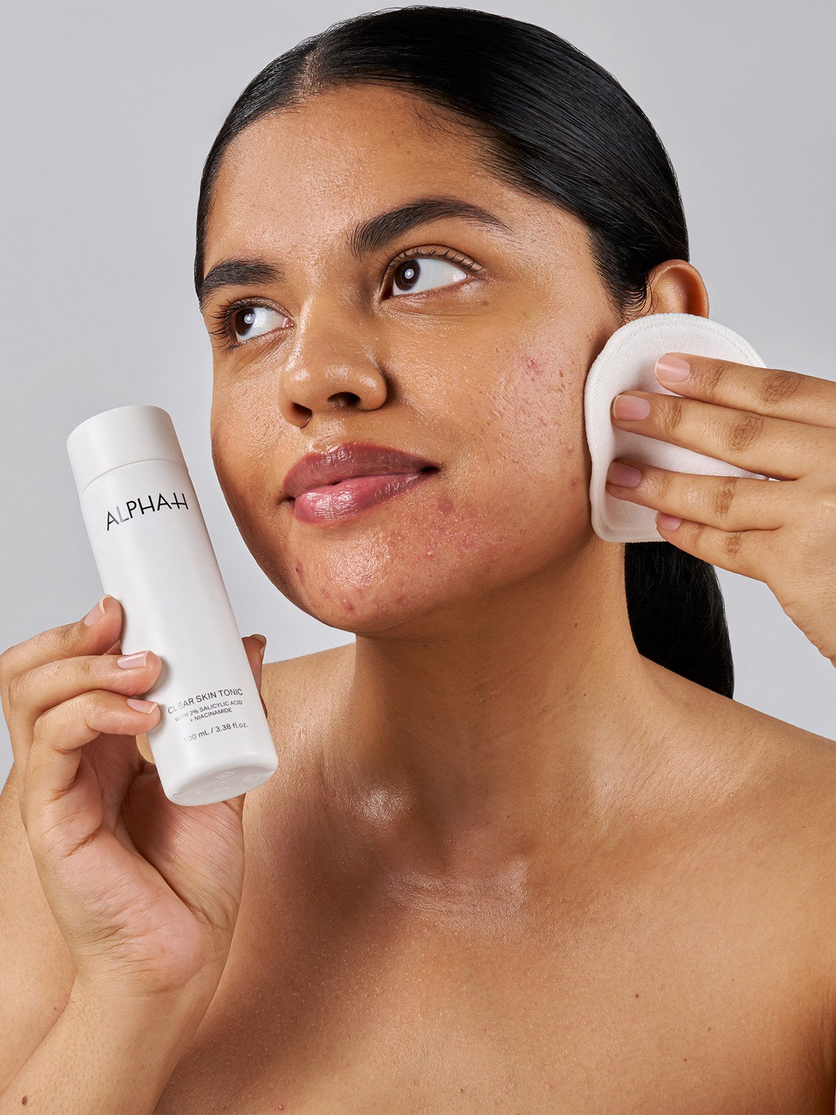Alpha-H Clear Skin Tonic applicazione con dischetto di cotone