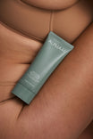 Alpha-H Daily Dose Multivitamin Body Serum tubo accanto al braccio