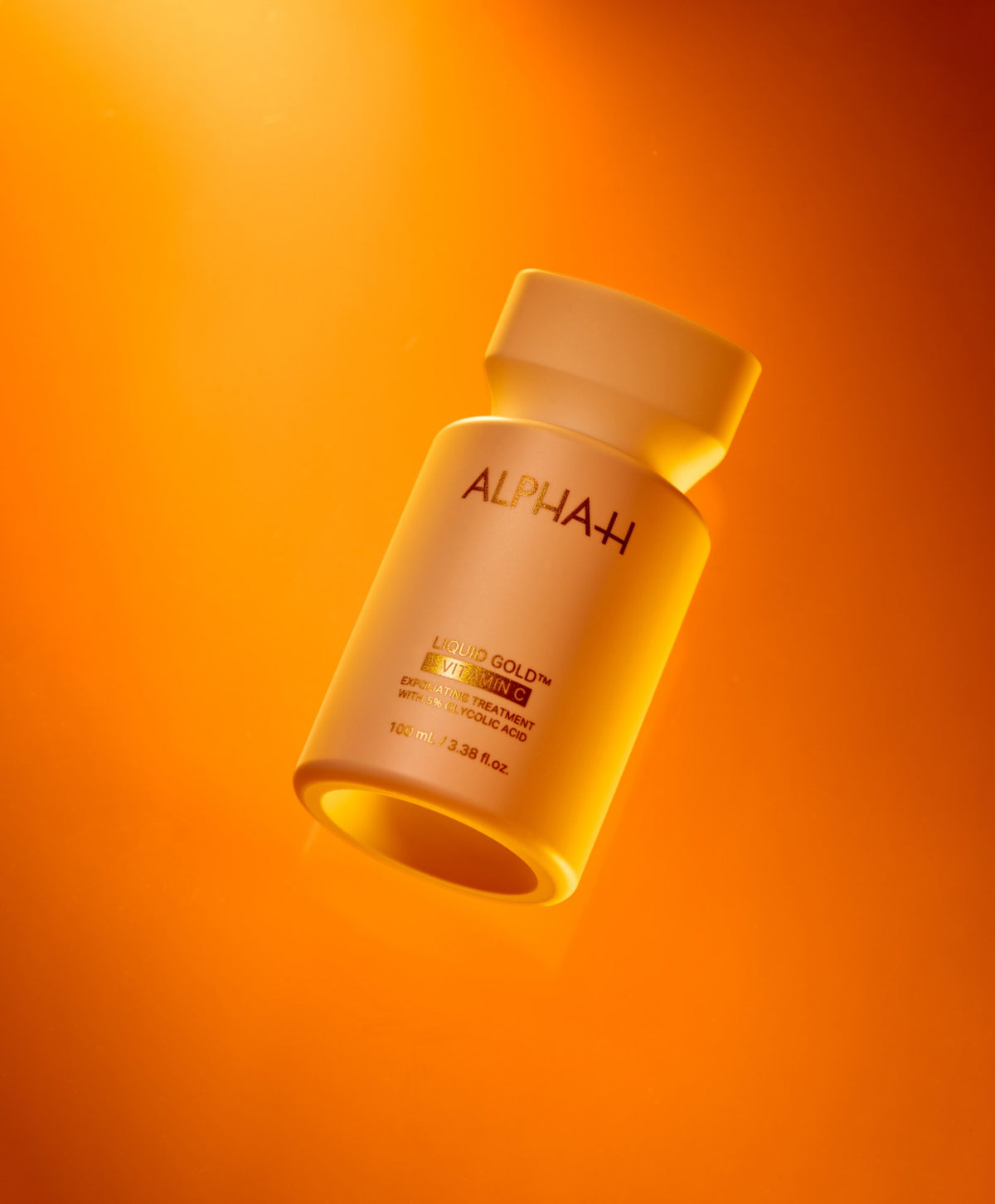 Alpha-H Liquid Gold + Vitamin C Exfoliating Treatment flacone in luce arancione