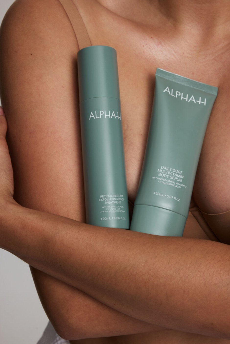 Alpha-H Retinol Reboot Exfoliating Body Treatment flacone appoggiato al braccio