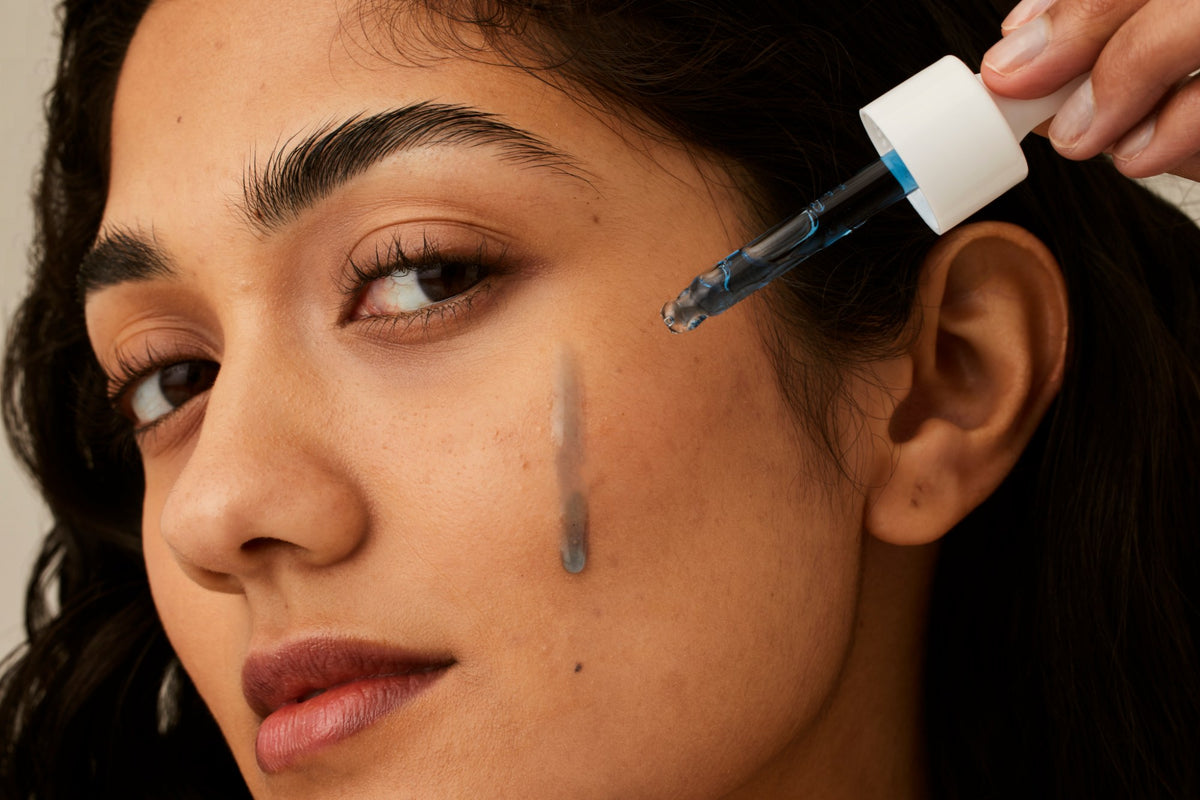 Alpha-H Vitamin B Serum modella con il siero sulla guancia