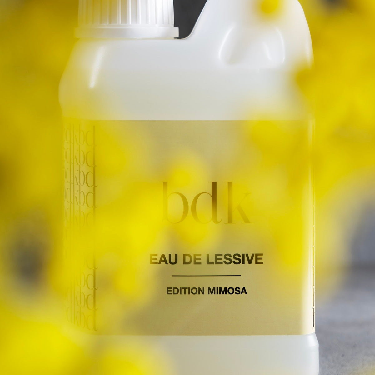 BDK Parfums Eau De Lessive Mimosa fles achter gele mimosatakjes