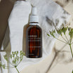 Oolaboo Super Foodies Matcha Infused Oil su telo di lino con fiori