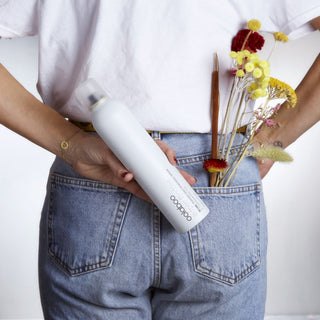 Oolaboo Super Foodies Transform Finishing Spray in een achterzak met bloemen